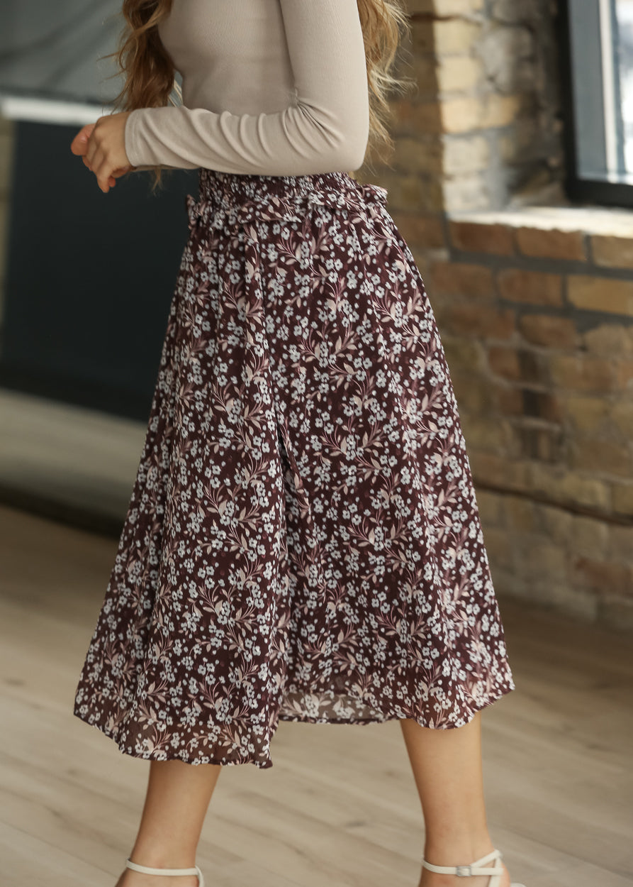 Side view of brown floral midi skirt showing its soft drape and mid-calf length.