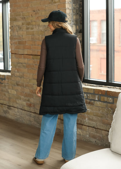 Back of black long puffer vest showing the straight sleeveless silhouette and quilted design.