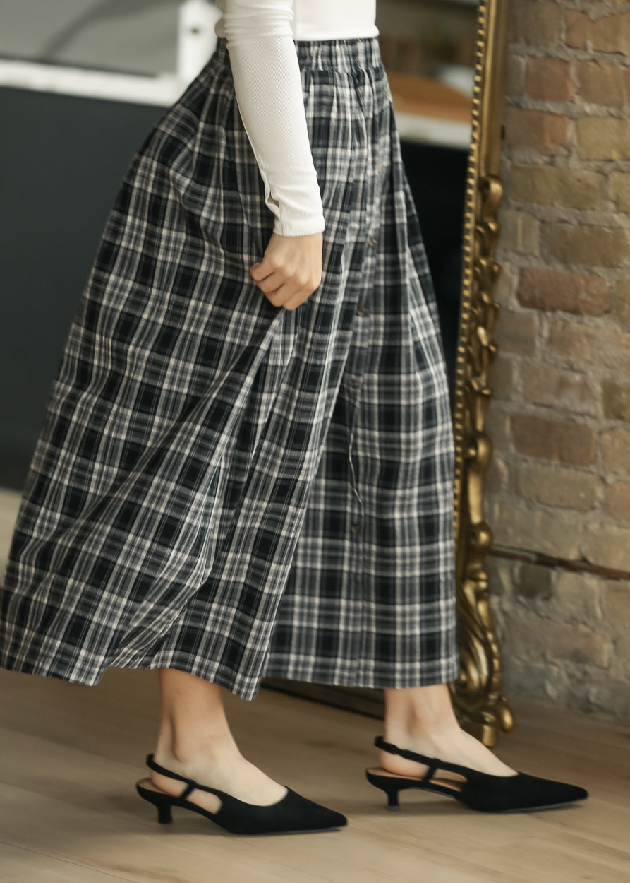 Black plaid midi skirt with full A-line silhouette, styled with black slingback heels.