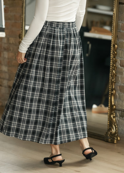 Back of black plaid midi skirt showing the gathered waistband and flowing A-line shape.