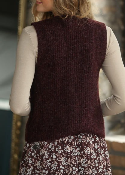 Back of burgundy sweater vest showing the soft textured knit and hip-length fit.
