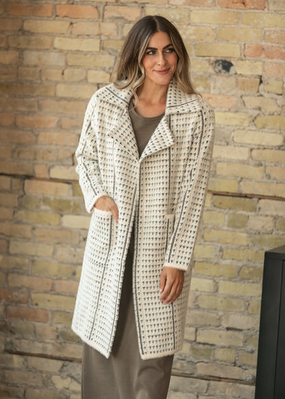 Cream and blue-gray houndstooth coat with oversized lapels and patch pockets, styled over a taupe maxi dress.