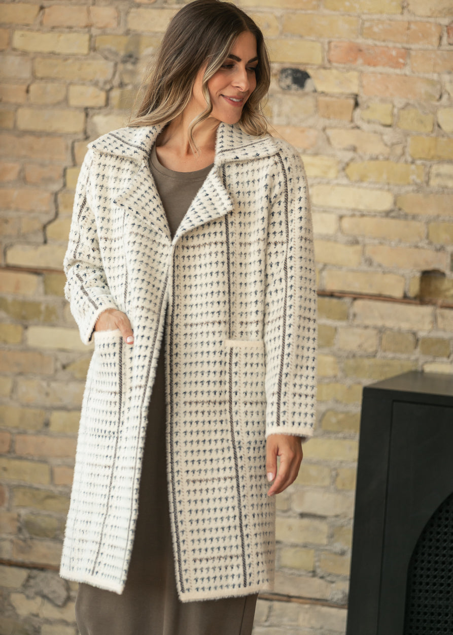 Marceau cream houndstooth coat with oversized lapels and front patch pockets, styled over a taupe maxi dress.