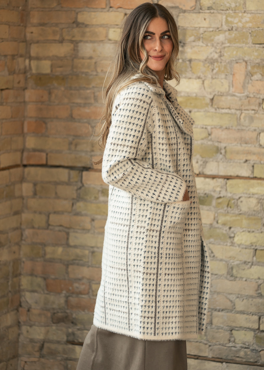 Side styling of the Marceau houndstooth coat with patch pocket and semi-fitted knee-length silhouette.