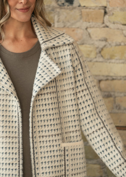 Close-up of the Marceau coat collar, textured houndstooth fabric, and blue-gray pattern detail.