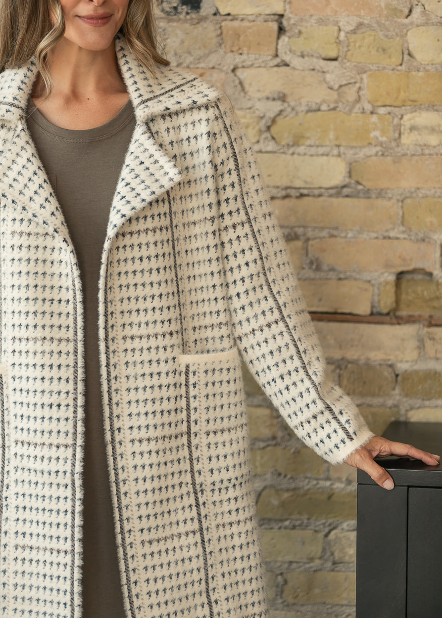 Marceau houndstooth coat showing oversized lapels, long sleeves, and large front patch pockets.
