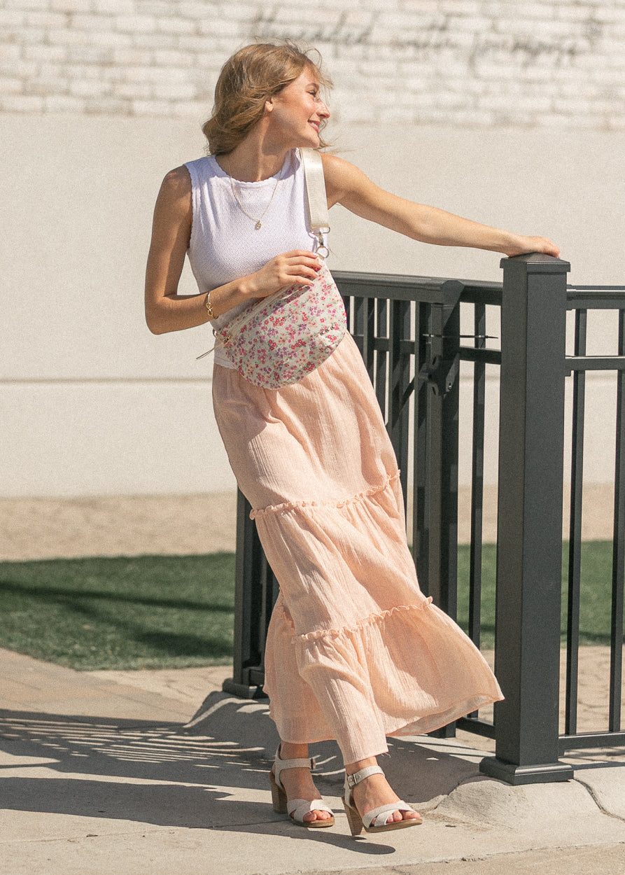 White sleeveless scalloped knit top styled with a blush maxi skirt and neutral sandals.