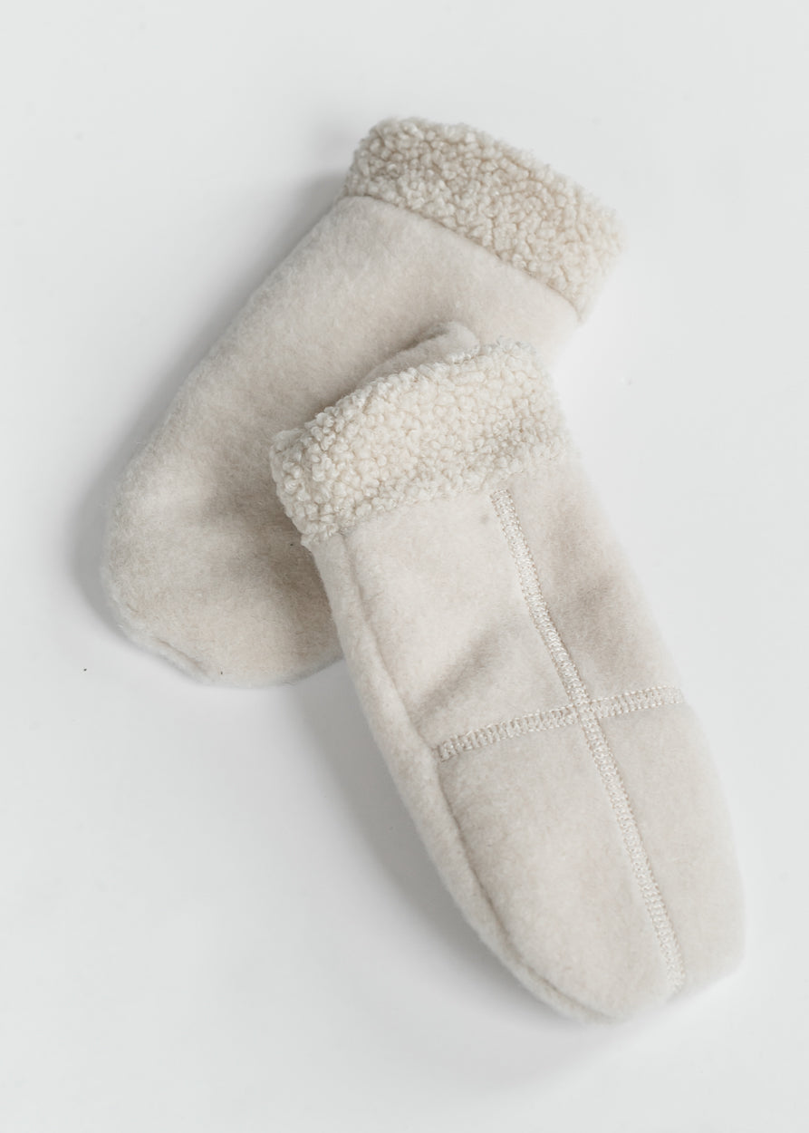 Pair of ivory cross-stitch mittens showing plush sherpa cuffs, soft fabric, and mitten shape.