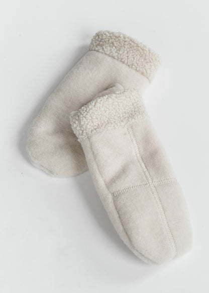 Pair of ivory cross-stitch mittens showing plush sherpa cuffs, soft fabric, and mitten shape.