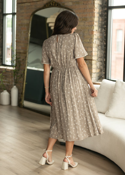 Back of brown floral midi dress showing keyhole closure, gathered waist, and short sleeves.