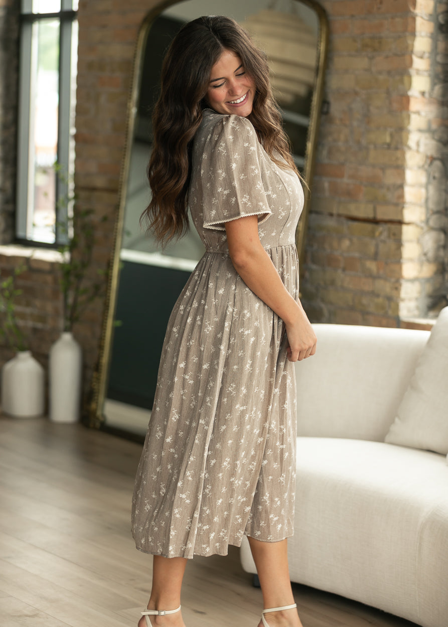 Full back view of brown floral midi dress with gathered waist and flowing midi skirt.