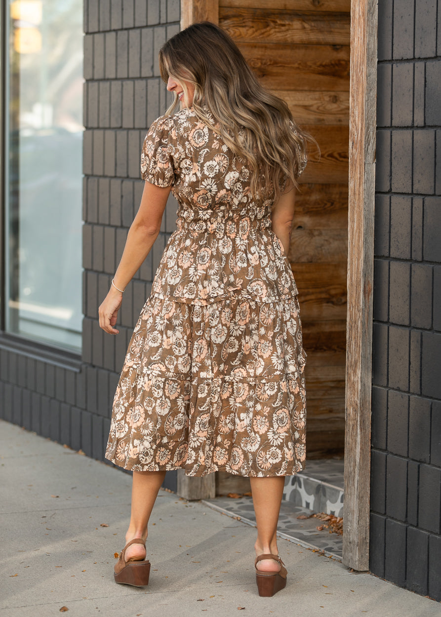 Back view of tiered floral midi dress with short puffed sleeves.
