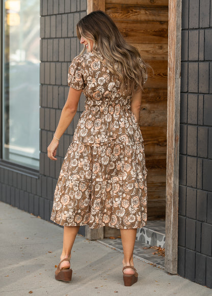 Back view of tiered floral midi dress with short puffed sleeves.