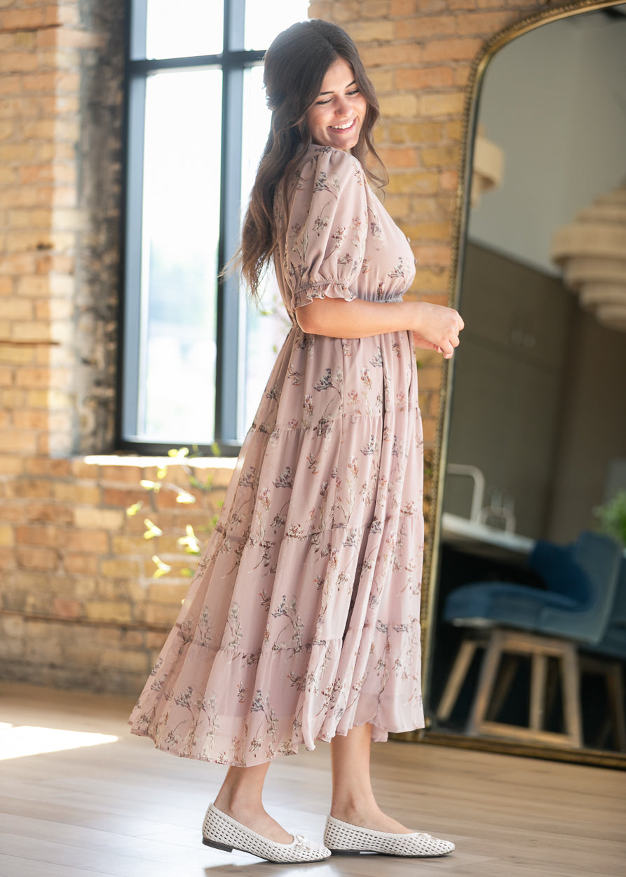 Side view of blush pink floral maxi dress showing the elasticized waist and flowing tiered skirt.