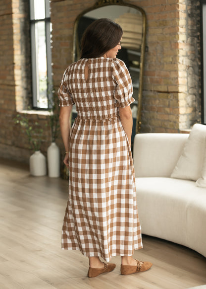 Back of brown and cream plaid midi dress showing smocked bodice, puff sleeves, and gathered waist.