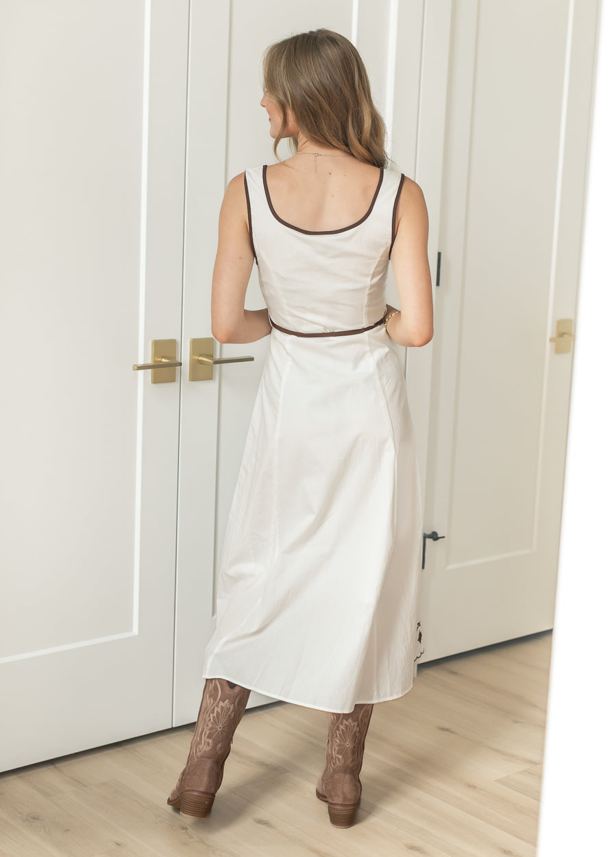 Side view of sleeveless embroidered midi dress with flowing skirt