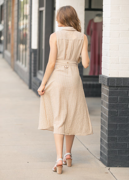 Back view of sand beige striped midi dress with collared neckline and flowing midi-length skirt.