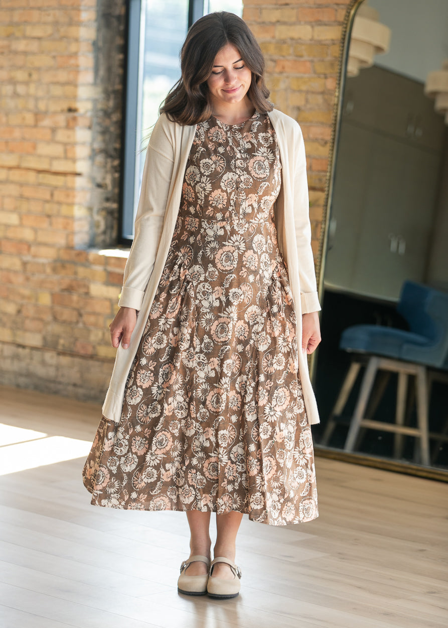 Brown and cream floral sleeveless midi dress with gathered waist detail and A-line silhouette.