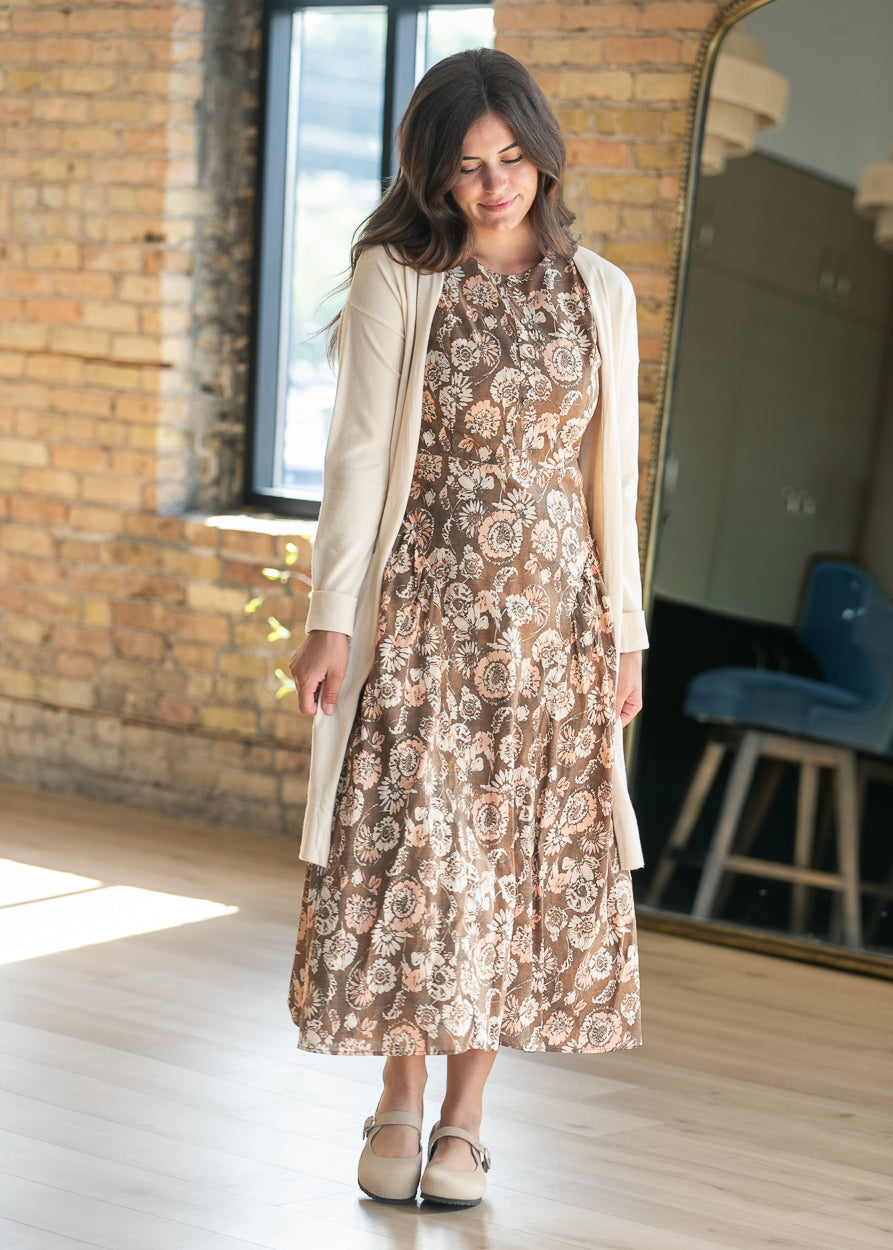 Sleeveless floral midi dress styled with cream platform shoes and neutral cardigan.