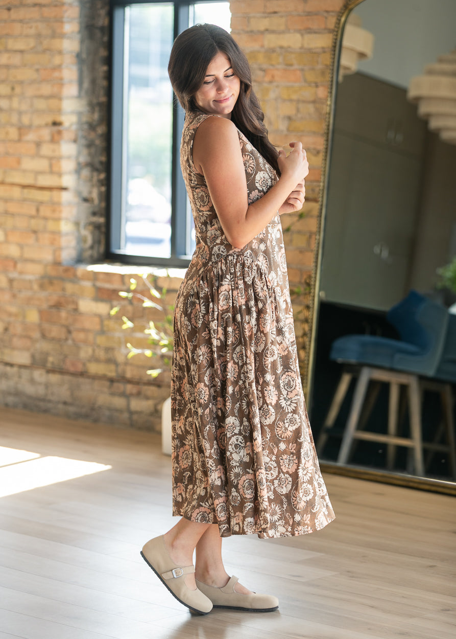 Side view of sleeveless midi dress showing the waist detail and flowing A-line skirt.