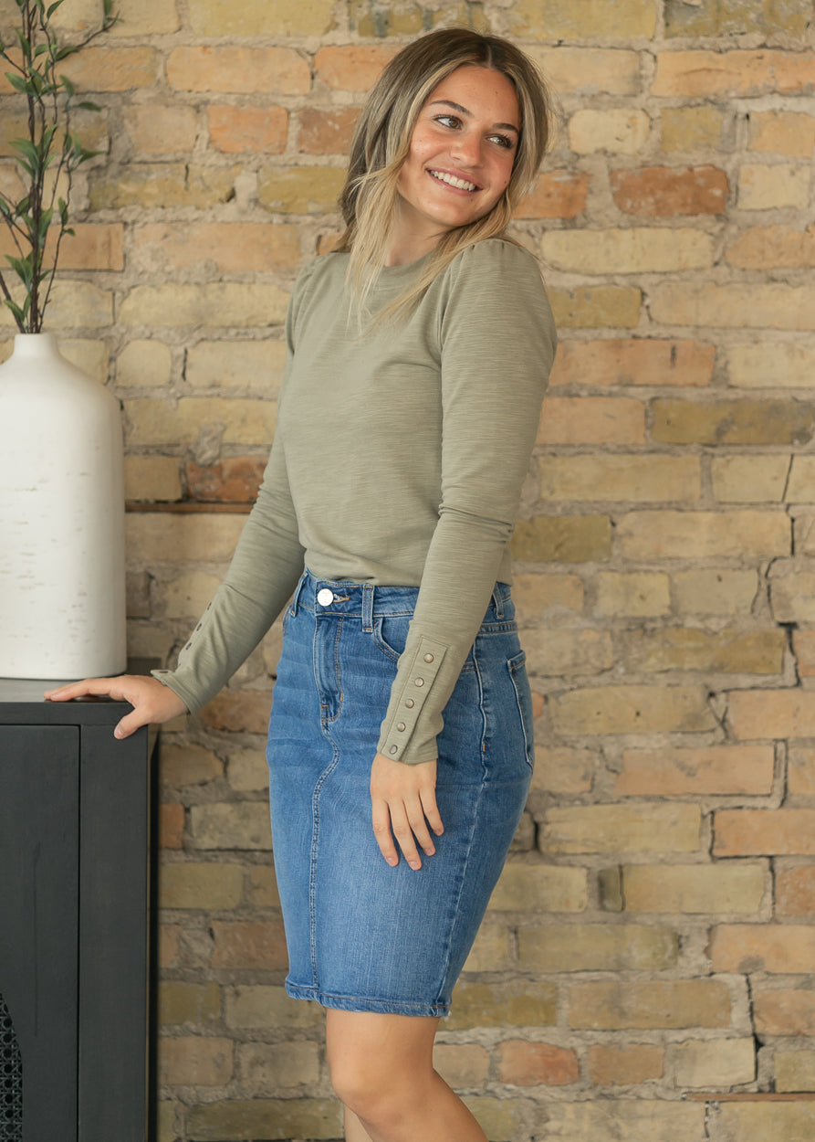Full-length look featuring the sage long sleeve top tucked into a medium wash denim skirt.