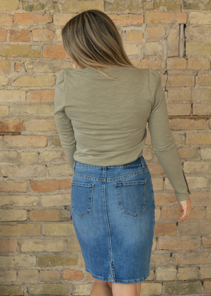Sage long sleeve top styled with a medium wash denim skirt, showing the fitted back.