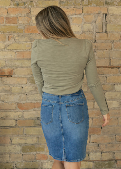 Sage long sleeve top styled with a medium wash denim skirt, showing the fitted back.