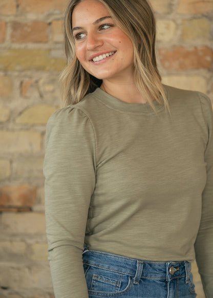 Close-up of sage slub knit top showing crew neckline, textured fabric, and puff shoulder detail.