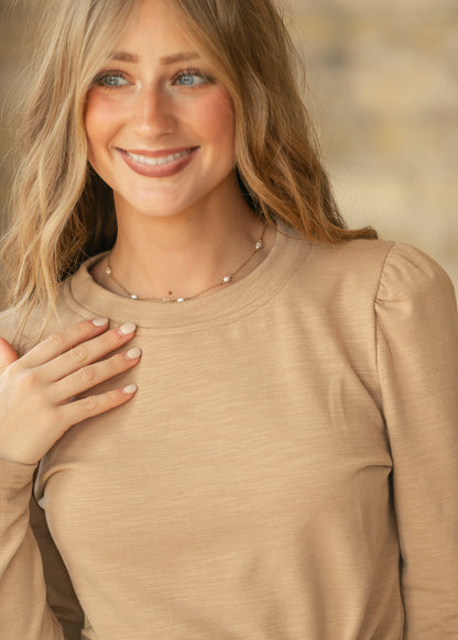 Taupe slub knit long sleeve top with subtle puff shoulders and a fitted silhouette.