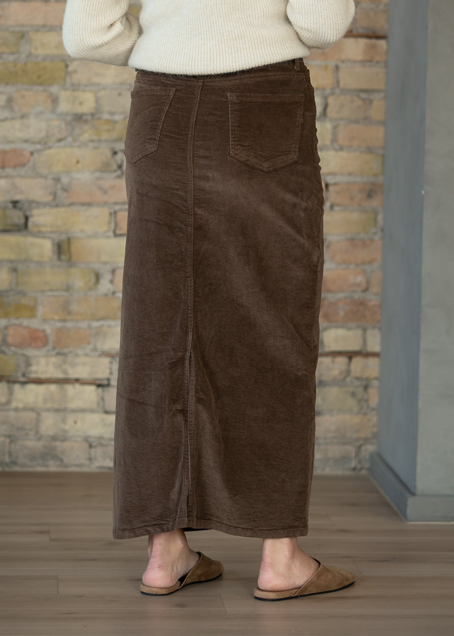 Brown corduroy maxi skirt shown full length with an ankle-length hem and semi-fitted shape.