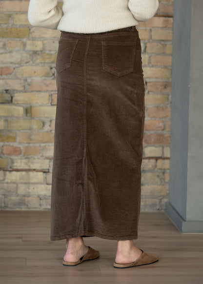 Brown corduroy maxi skirt shown full length with an ankle-length hem and semi-fitted shape.
