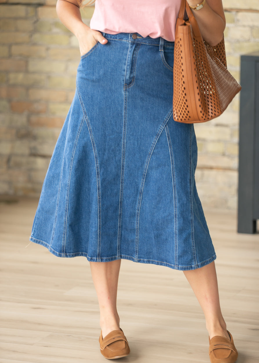 Medium wash denim midi skirt with stitch detail panels and front pockets styled with a pink blouse.
