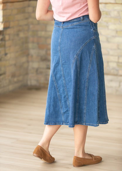 Back detail of medium wash denim midi skirt with stitched panel design and modest midi length.