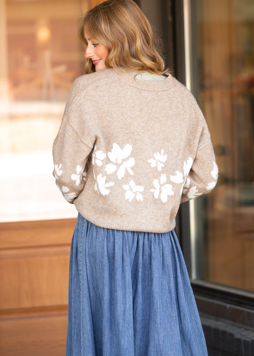 Back of oatmeal floral knit cardigan showing the relaxed fit, drop shoulders, and ivory jacquard pattern.