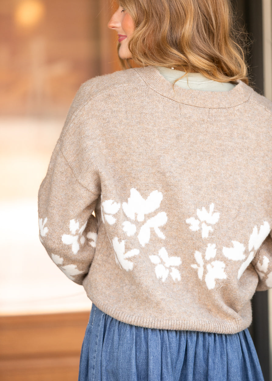 Heathered oatmeal floral jacquard cardigan with ivory flowers and ribbed trim, shown from the back.
