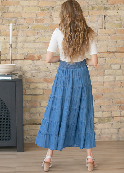 Back view of blue chambray maxi skirt with smocked waistband detail
