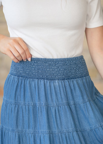 Close view of smocked elastic waistband on blue chambray maxi skirt