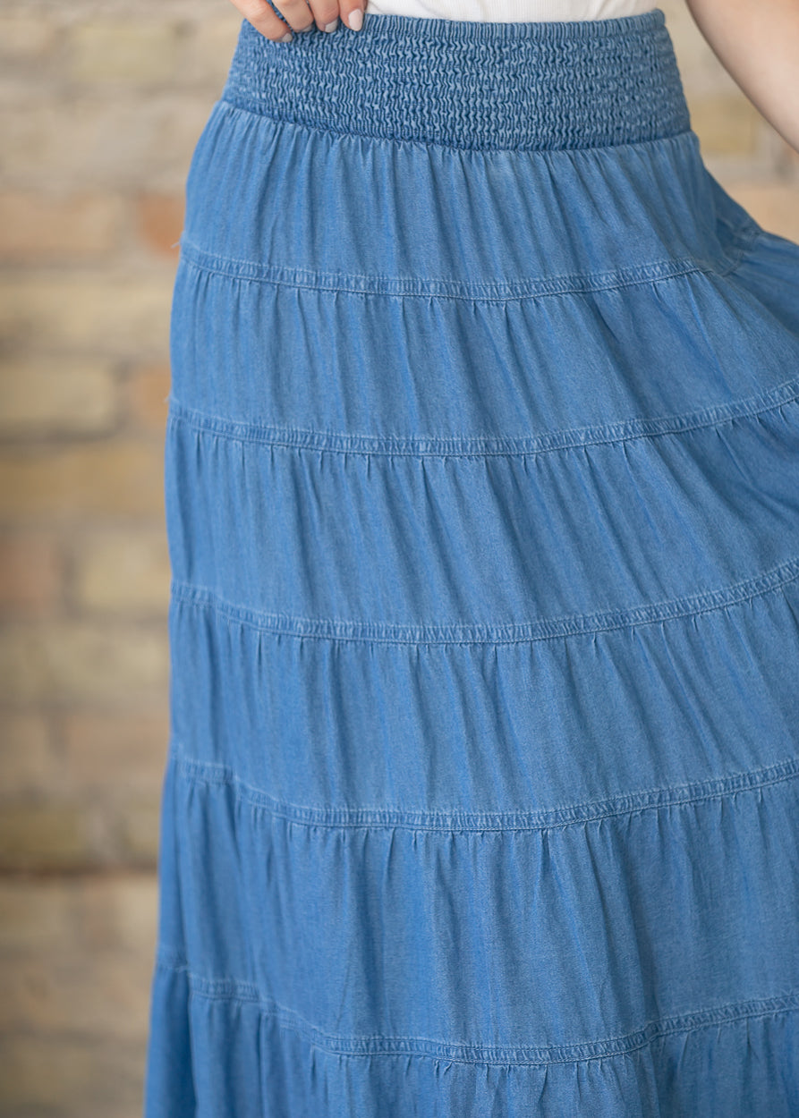Close view of smocked elastic waistband on blue chambray maxi skirt