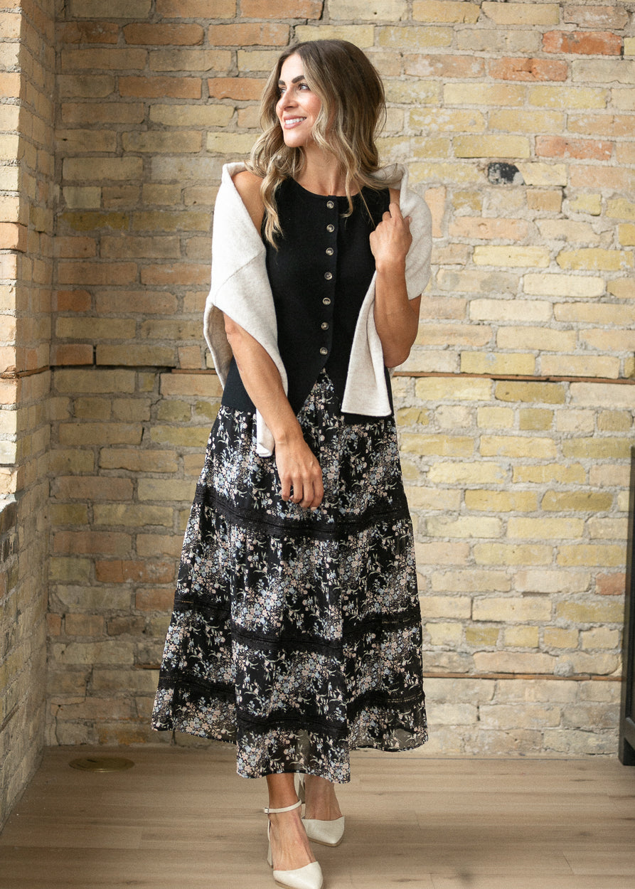 Sunday Floral Midi Skirt styled with a black top, cream sweater, and heels.