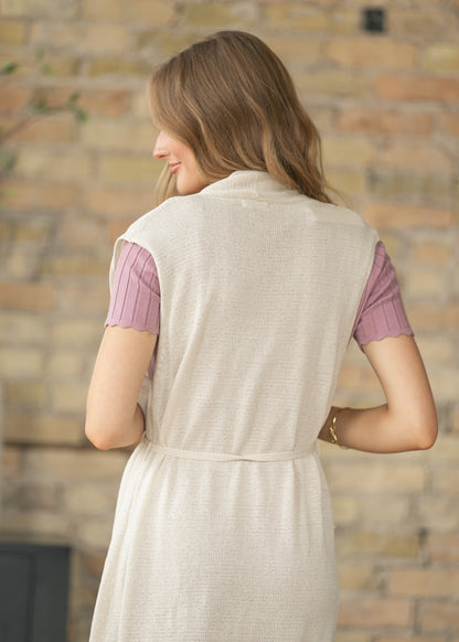 Sleeveless belted cardigan styled over a ribbed midi dress