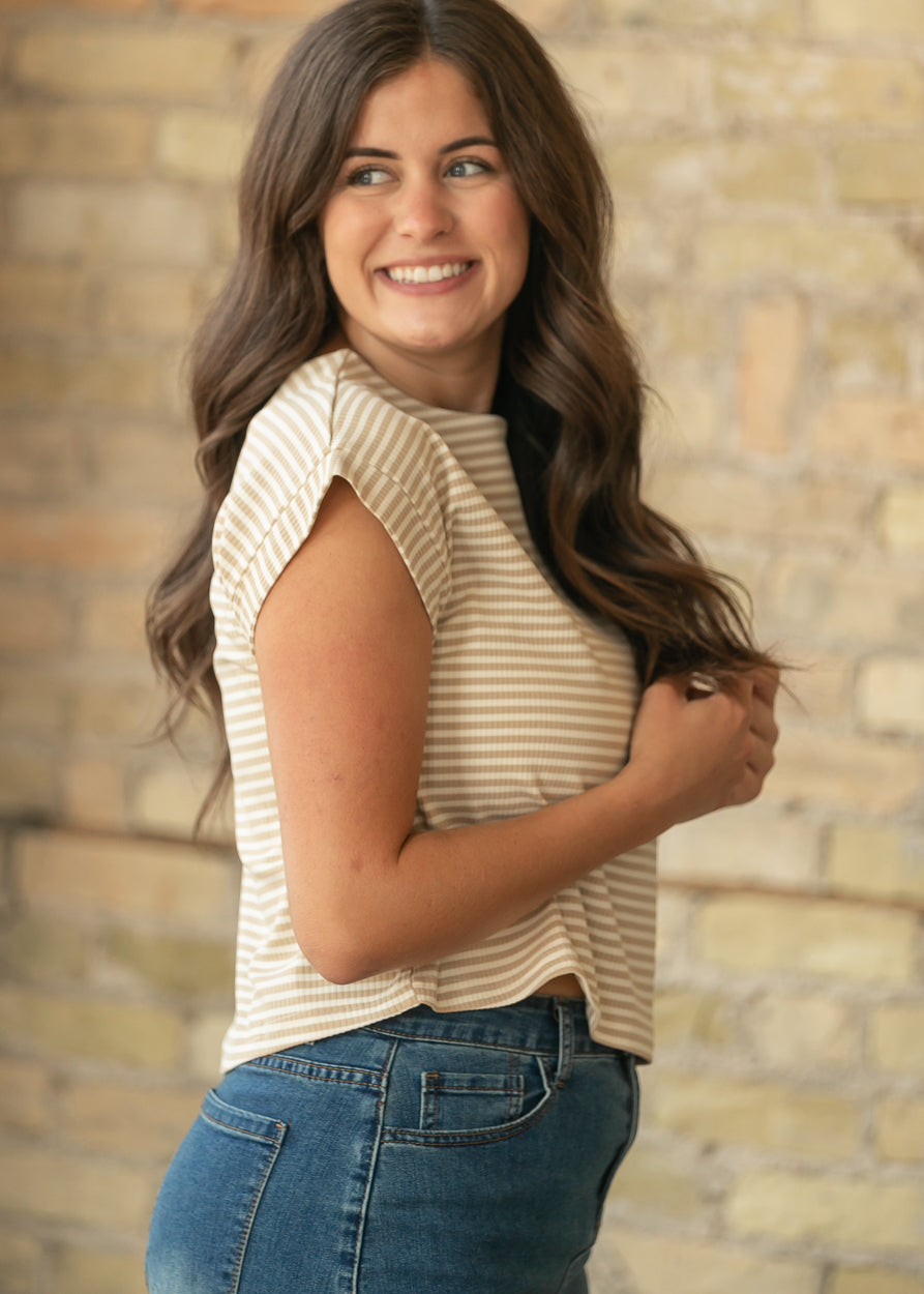 Side view of taupe stripe boxy top styled with a dark wash denim midi skirt.