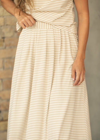 Close-up of taupe stripe rib knit midi skirt showing the wide waistband and gathered construction.
