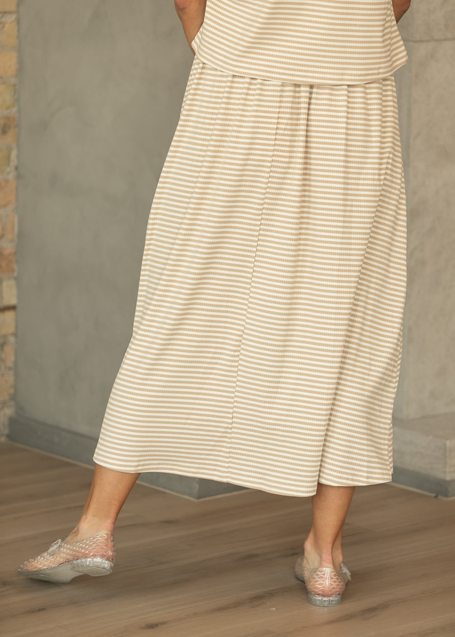 Back of taupe stripe rib knit midi skirt styled with the coordinating striped top and clear flats.