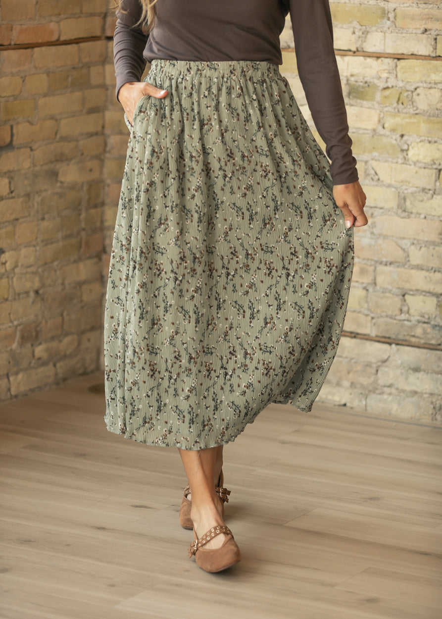 Sage floral midi skirt with flowy silhouette, elastic waist, and brown flats.