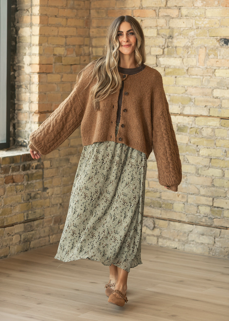 Sage floral midi skirt styled with a brown cardigan, long sleeve top, and flats.