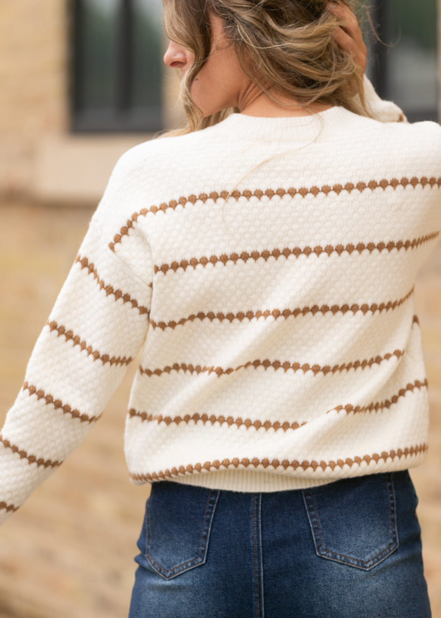 Back of cream and brown striped sweater showing textured knit, relaxed shoulders, and ribbed hem.