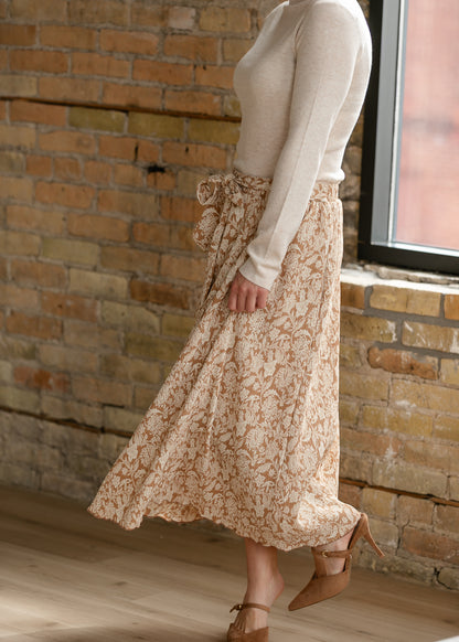 Side view of taupe floral midi skirt showing soft drape and ankle-grazing midi length.
