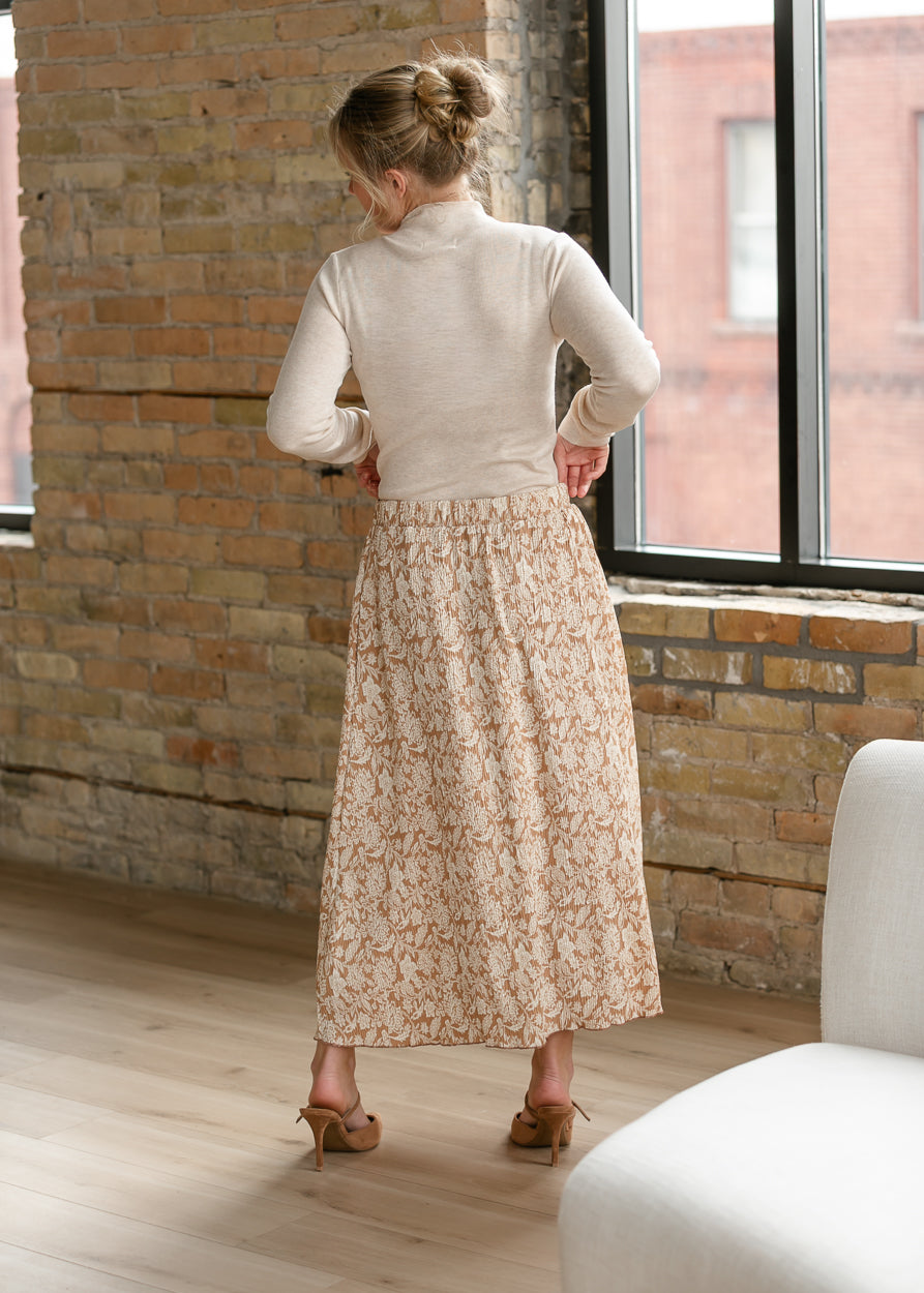 Back of taupe floral midi skirt showing elastic waistband and flowing silhouette.