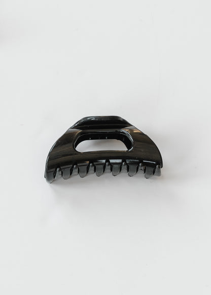 Glossy black flexible claw clip shown from the front with curved claws and open center.