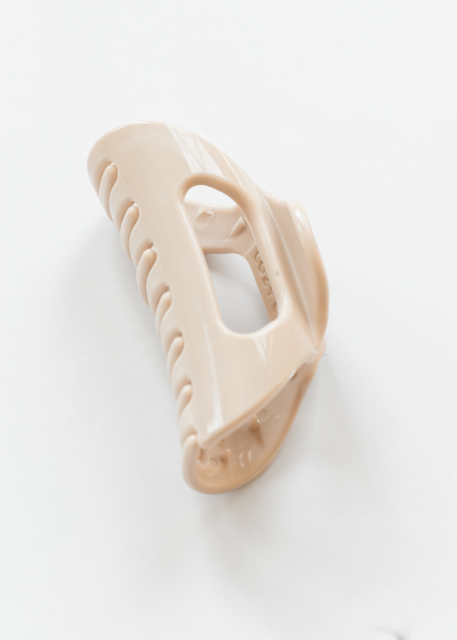 Creamy blonde flexible claw clip angled to show curved teeth and open center construction.
